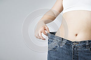 Young woman in jeans of large size, concept of weight loss