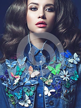 Young woman in jeans with a lot of brooches