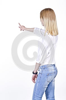 Young woman in jeans pointing to the virtual object