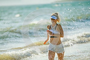 Young woman jogger on seacoast in evening running