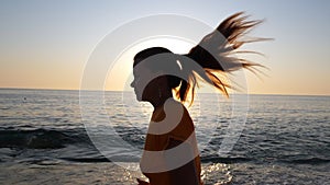 A young woman jogging along the sandy sea beach.