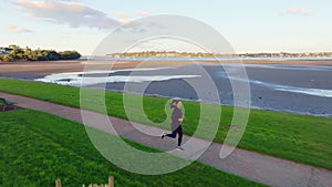 Young woman jogging by beach