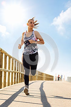 Young woman jogging on bridge