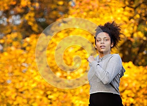 Young woman jogging outdoors in autumn