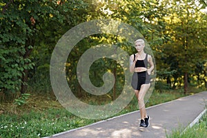 Young woman jogging on a park trail at dawn