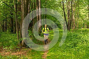 young woman jogging on a path in a natural forest park