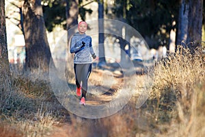 Young woman jogging on trail in autumn park