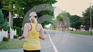 A young woman jogs along a typical US suburb