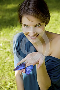Young woman joyfull playing with butterfly