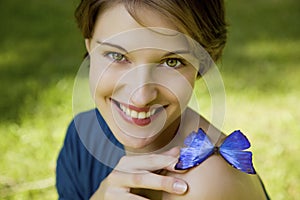 Young woman joyfull playing with butterfly