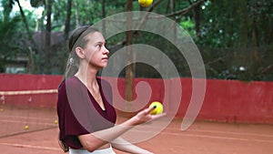 young woman juggling tennis balls on the court