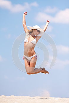 Young woman jumping on a beach