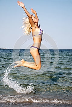 Young woman jumping in the beach