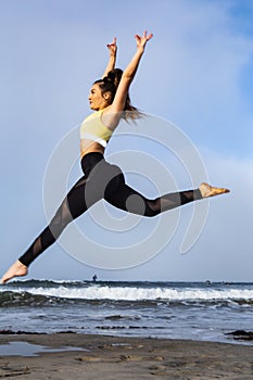 young woman jumping at the beach
