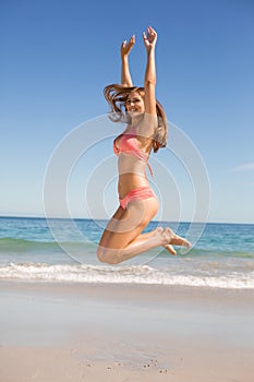 Young woman jumping on beach