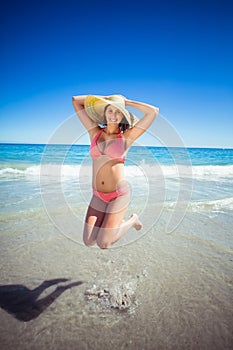 Young woman jumping on beach