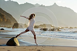 Young woman jumping on the beach in summer