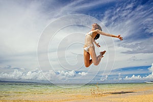 Young woman jumping at the beach on Taveuni Island, Fiji