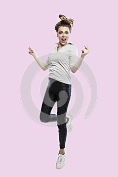 Young woman jumping. Beautiful smiling blonde in black leggings and a gray tank top. Happiness, joy and movement. Isolated on a