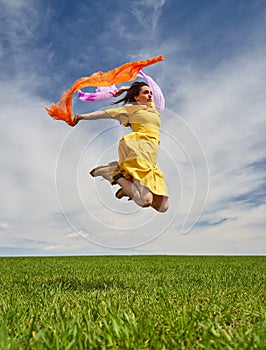 Young woman jumping for joy on a wheat field