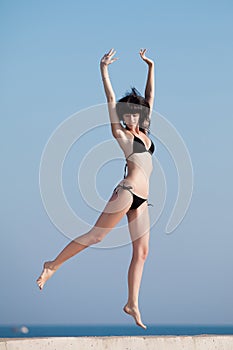 Young woman jumping on open air