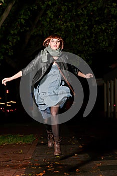 Young woman jumping over a puddle