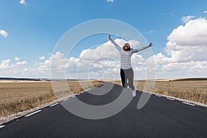 Young woman jumping on the road on nowhere