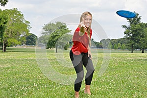 young woman jumping throwing flying disc