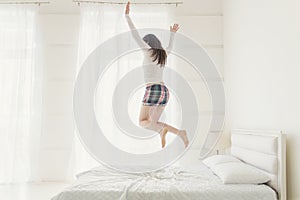 Young woman jumping up with hands raised up