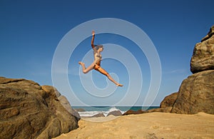 Young woman jumps from rocks