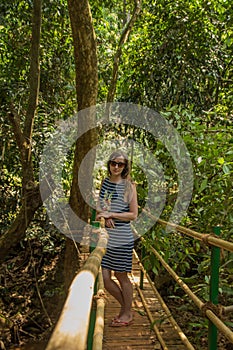 Young woman in the jungle on the bridge in tropical spice plantation, Goa, India