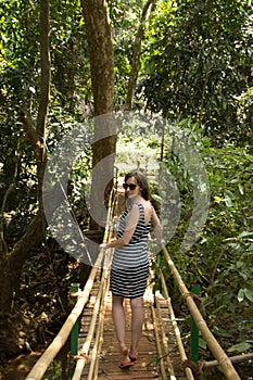 Young woman in the jungle on the bridge in tropical spice plantation, Goa, India