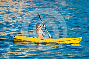 Young woman in a kanu kayak exercising in the ocean