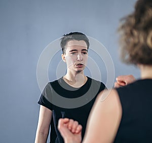 Young woman karate student with her trainer in gym. Taekwondo coach teaching adult woman in personal training. Two women