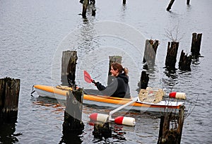 Young Woman Kayaks In Pilings