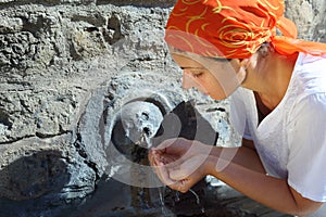 Young woman in kerchief drinking water photo