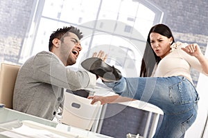 Young woman kicking boyfriend