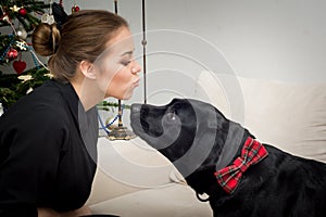 Young woman kissing Christmas dog