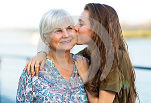 Young woman kissing her grandma photo