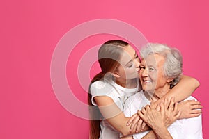 Young woman kissing her grandmother. Space for text