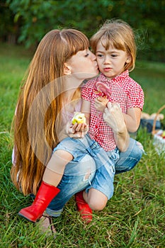 Young woman kissing her little daughter