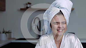 Young woman in kitche during quarantine. Girl in bath clothes after taking shower or spa laughing out loud. Have fun