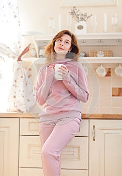 Young woman in the kitchen with the cup of tea