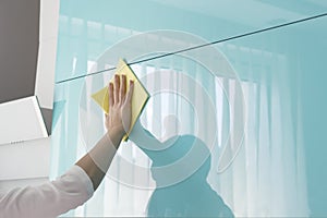 Young woman in the Kitchen doing Housework cleaning cupboards