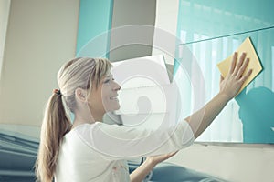 Young woman in the Kitchen doing Housework cleaning cupboards