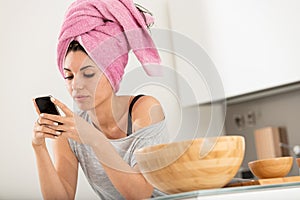 Freshly washed hair, girl on smartphone, bright kitchen, multita photo