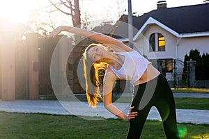 Young woman kneads before running at sunset