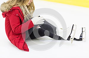 Young woman with knee trauma on skating rink