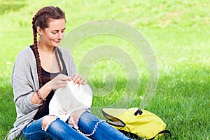 Young woman knits with knitting needles