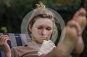 Young woman knits out of wool outdoors